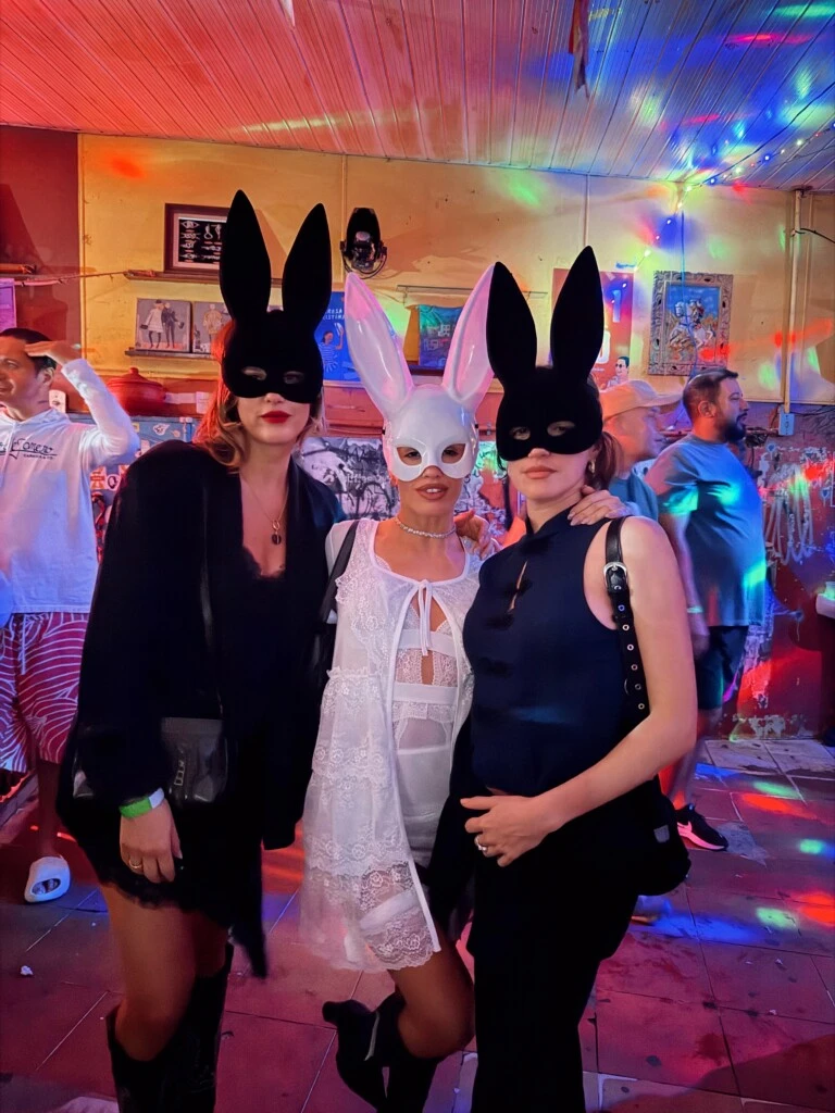 El grupo eligió outfits negros y los acompañó con máscaras del mismo tono. Lali, en cambio, se diferenció con un vestido blanco de encaje y transparencias, un saquito liviano y una máscara blanca.