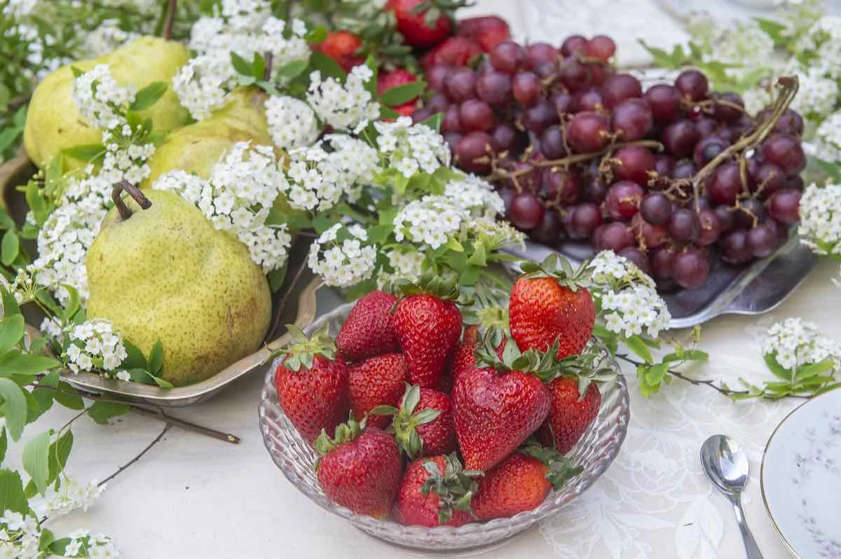 Peras, frutillas y uvas intervienen el blanco, la paleta neutra y el verde y aportan los acentos de color de la mesa.