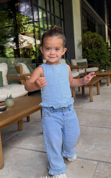 Olivia, la hija de Sergio “Kun” Agüero y Sofía Calzetti, volvió a conquistar con uno de sus looks. Esta vez, lució un conjunto de jean celeste que reúne comodidad, frescura y uno de los detalles que gana protagonismo en la moda: los volados.
La pequeña llevó una remera sin mangas y un pantalón amplio confeccionados en denim liviano. Ambas prendas incorporan terminaciones con volados, el recurso encargado de transformar el clásico total look de jean en una propuesta mucho más romántica.
Olivia se sumó a la tendencia del “denim romántico”
El denim romántico propone suavizar la estética urbana y descontracturada del jean mediante detalles delicados como volados, bordados, lazos, frunces y terminaciones onduladas.
En el look de Olivia, los volados aparecen en la cintura de la remera y en los ruedos del pantalón, generando movimiento y aportándole un aire divertido al conjunto.
La elección del mismo tono de jean en ambas prendas crea un efecto total denim o denim on denim, otra tendencia que continúa vigente y permite lograr un outfit coordinado sin demasiados elementos.
Las claves del look de Olivia
La parte superior presenta un diseño sin mangas, de líneas simples y con un pequeño volado en la terminación. El pantalón, en tanto, se destaca por su silueta holgada y cómoda, además de repetir el detalle de volados a la altura de los tobillos.
Para completar el outfit, Olivia llevó zapatillas blancas, un básico que acompaña la estética relajada del conjunto y permite que el denim sea el verdadero protagonista.
Su pelo recogido en un rodete alto terminó de darle al estilismo un toque fresco y práctico.
Cómo llevar la tendencia del jean con volados
Los volados ofrecen una forma original de renovar las prendas de jean y pueden aparecer en camisas, tops, vestidos, polleras, camperas o pantalones.
Para adoptar esta tendencia, se puede elegir una única prenda intervenida y combinarla con básicos neutros. Otra posibilidad es seguir la fórmula de Olivia y apostar por un conjunto coordinado, utilizando el mismo tono de denim de pies a cabeza.
sofia calzetti y el look de su hija Olivia