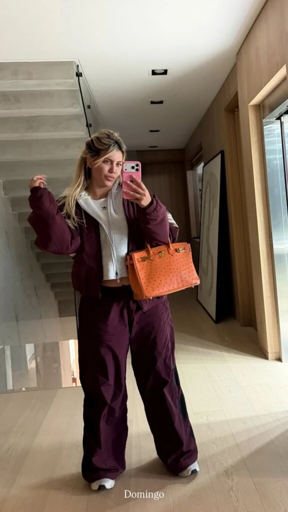 La cartera se destacó por su intenso tono naranja zanahoria y sus herrajes dorados. El color generó un contraste marcado con el borgoña del conjunto y convirtió al accesorio en el verdadero protagonista del outfit.