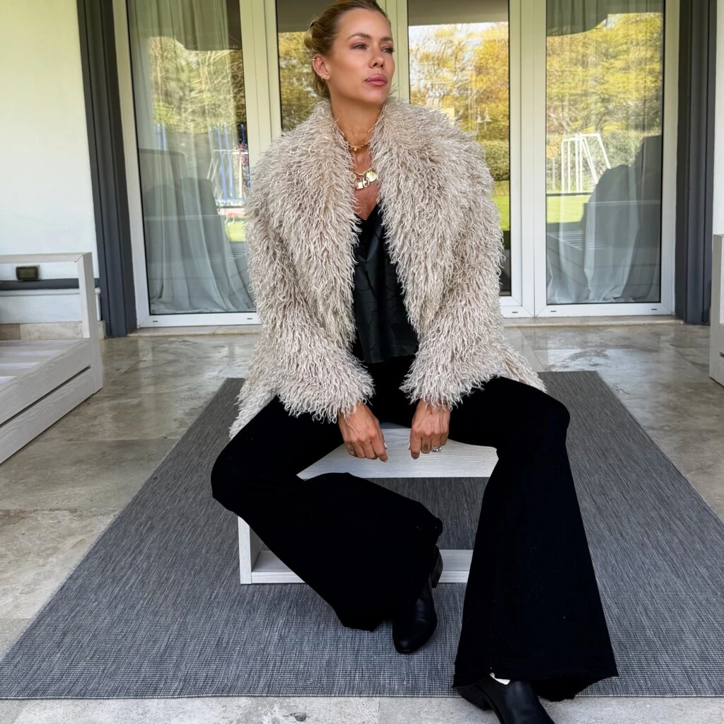 Nicole eligió un rodete bajo con raya al medio, un peinado pulido que dejó el rostro despejado y permitió que todo el protagonismo quedara en el volumen del abrigo.