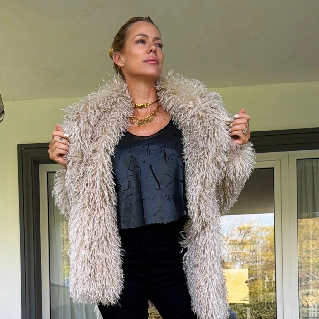 Debajo del tapado, Nicole construyó una base estilizada en color negro. La modelo combinó una remera con estampa craquelada y escote redondo, que aportó un brillo sutil, con un pantalón oxford de tiro alto.