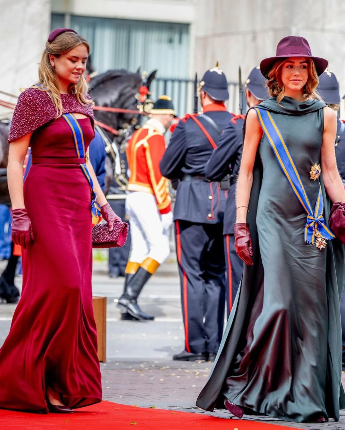 Alexia potenció su vestido verde con los accesorios
La princesa Alexia eligió un vestido verde petróleo de líneas depuradas. Un diseño de Reiss sin mangas y con una caída larga, al que sumó una especie de capa o pieza de tela que cae sobre los hombros y la espalda.
Pero en su look hay un detalle que merece especial atención: los accesorios son los que aportan carácter y color a un vestido de base mucho más sobria.
Alexia eligió un sombrero de Maison Michel, guantes de cuero y una cartera tipo pouch -de COS- en color bordó. El conjunto crea un contraste muy marcado con el tono del vestido y hace que los complementos tengan un papel protagonista.
La elección funciona justamente por ese juego de opuestos: una silueta sencilla y neutra como punto de partida y una serie de accesorios en una tonalidad profunda que le dan identidad al estilismo.
Entre ellos aparece, además, un detalle con historia familiar. El sombrero ya había sido utilizado por Máxima en 2018, de modo que Alexia incorporó una pieza del vestidor de su madre a una propuesta propia.