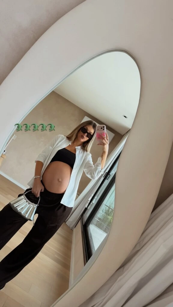 Como base, Stephanie eligió un top negro ajustado que dejó su pancita al descubierto y lo combinó con un pantalón de vestir a tono, de tiro bajo y silueta holgada.