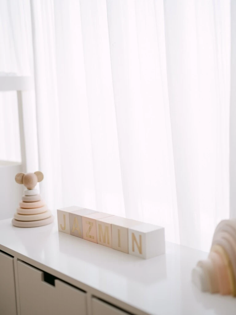 La organización se completa con un guardado de juguetes blanco y una cómoda amplia decorada con moños rosas.