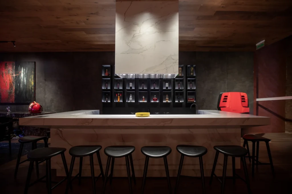 Una gran barra se integra a la propuesta y refuerza la idea del garage como lugar social: un espacio para recibir invitados, conversar y disfrutar de la colección.